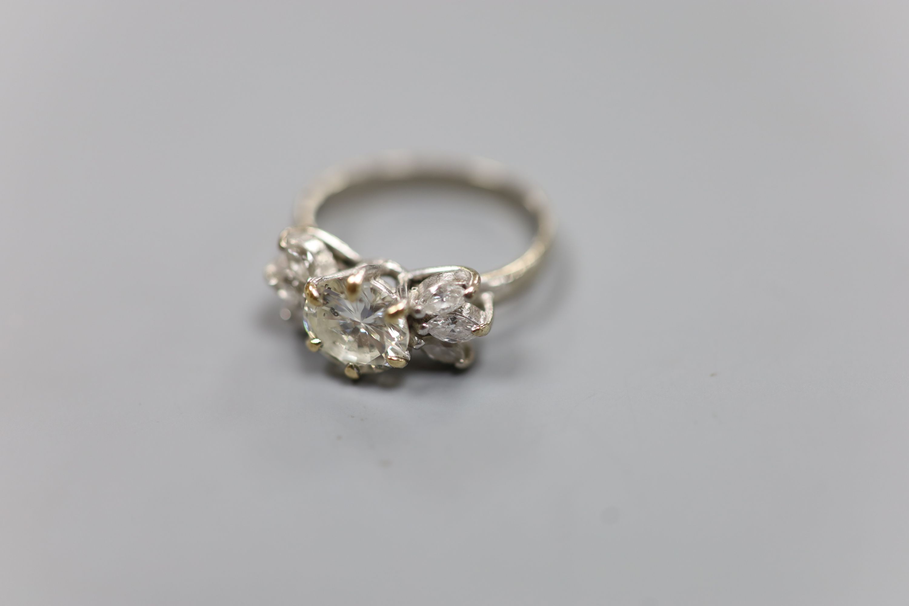 A white metal (stamped 18ct Plat) and single stone diamond ring, with six stone marquise cut diamond set shoulders, size K
